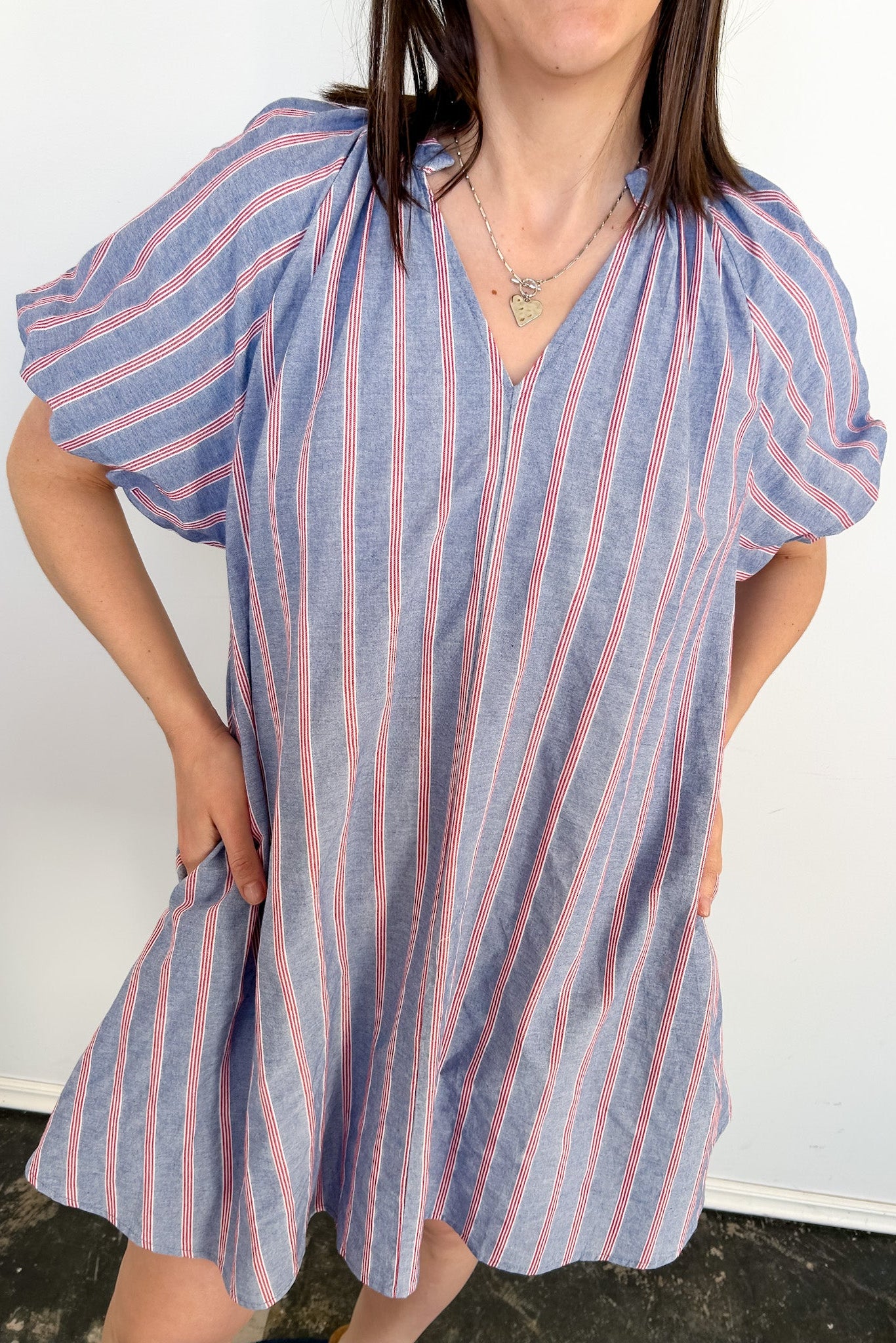 Woman wearing a blue and pink striped dress against a white background