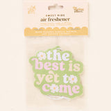 Air freshener with 'the best is yet to come' text on a light background