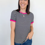 Woman wearing a black and white striped shirt with pink accents against a white background