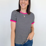 Woman wearing a black and white striped shirt with pink accents against a white background