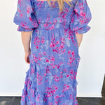 Flowy floral print dress with colors periwinkle and hot pink. Smocked bodice. Puff sleeves with tiered bottom. 