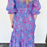 Flowy floral print dress with colors periwinkle and hot pink. Smocked bodice. Puff sleeves with tiered bottom. 