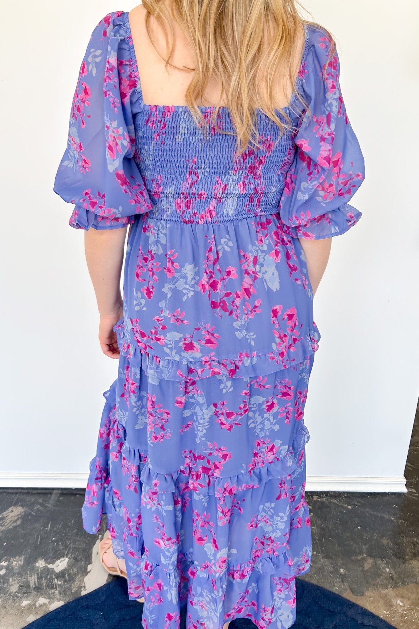 Flowy floral print dress with colors periwinkle and hot pink. Smocked bodice. Puff sleeves with tiered bottom. 