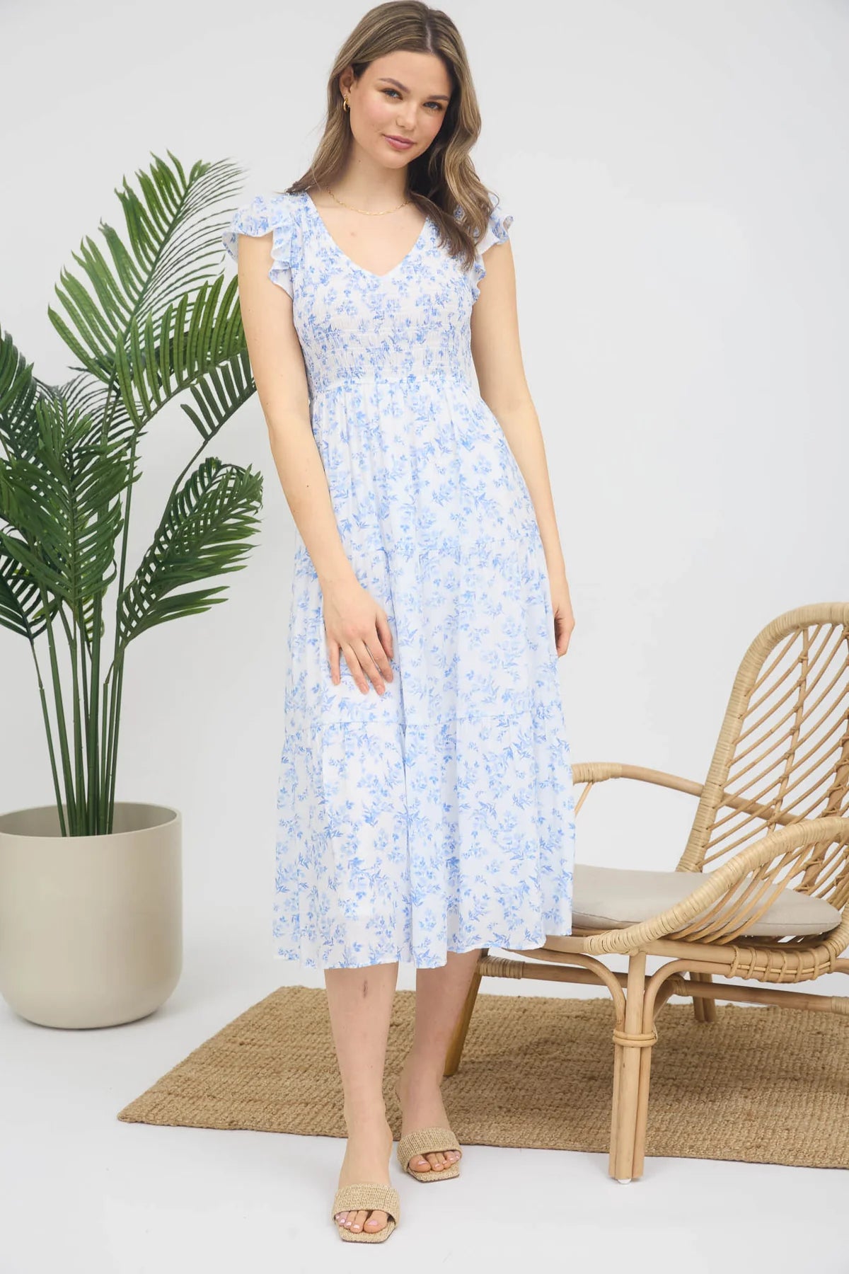 Floral print midi length dress. Blue and white in color. V neckline with flowy bottom and ruffles short sleeves.