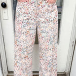 Person wearing floral pants standing in front of a door.