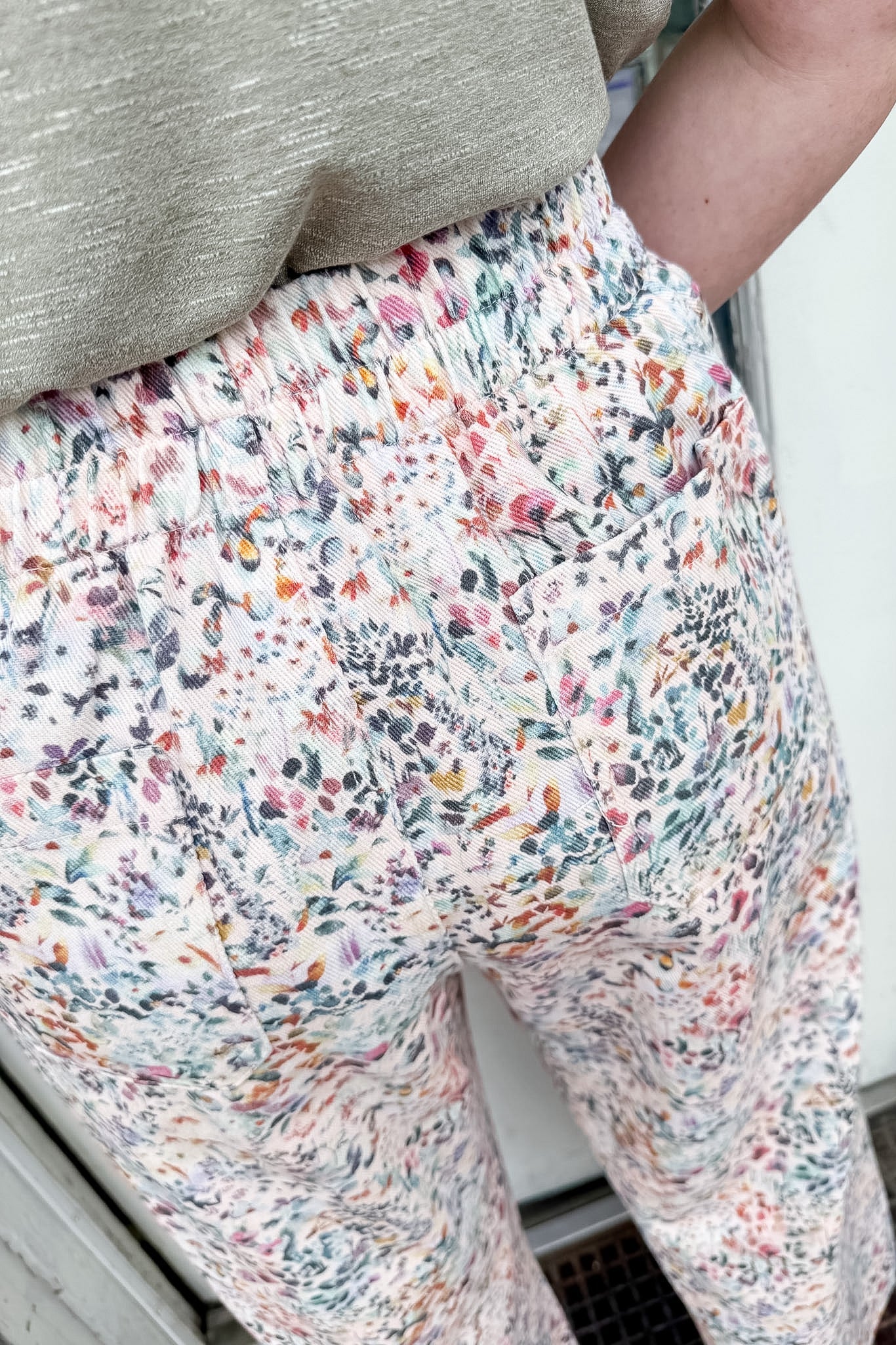 Person wearing colorful floral pants with a neutral background