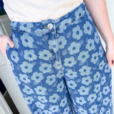 Floral print pants with a white tanks. The model has her hand on her hip.