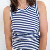 Woman wearing a blue and white striped tank top against a plain background