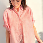 Woman wearing a red and white striped shirt against a plain background