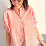 Woman wearing a red and white striped shirt against a plain background