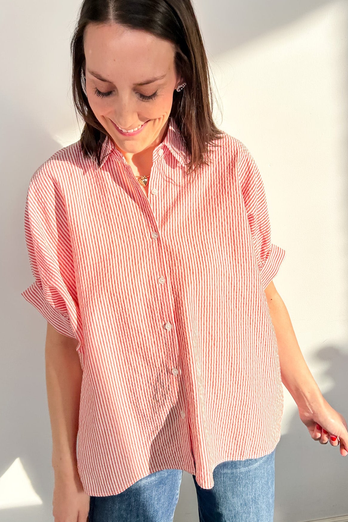 Woman wearing a red and white striped shirt against a plain background