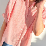 Person wearing a red and white striped shirt against a white background