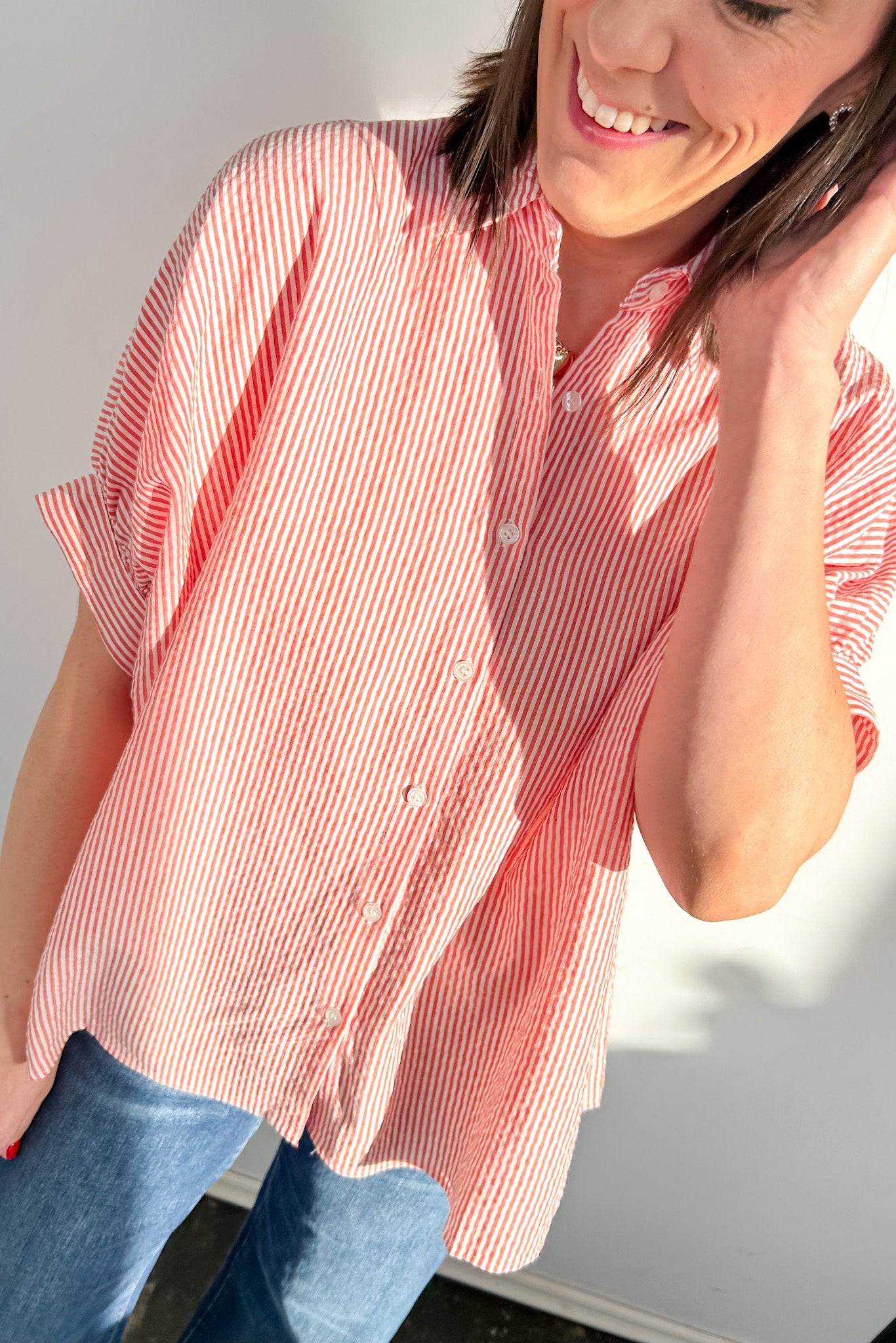 Person wearing a red and white striped shirt against a white background