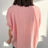 Person wearing a red and white striped shirt with a plain background