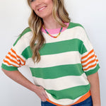 Woman wearing a colorful striped sweater against a white background