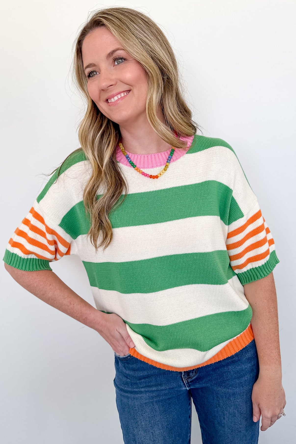 Woman wearing a colorful striped sweater against a white background
