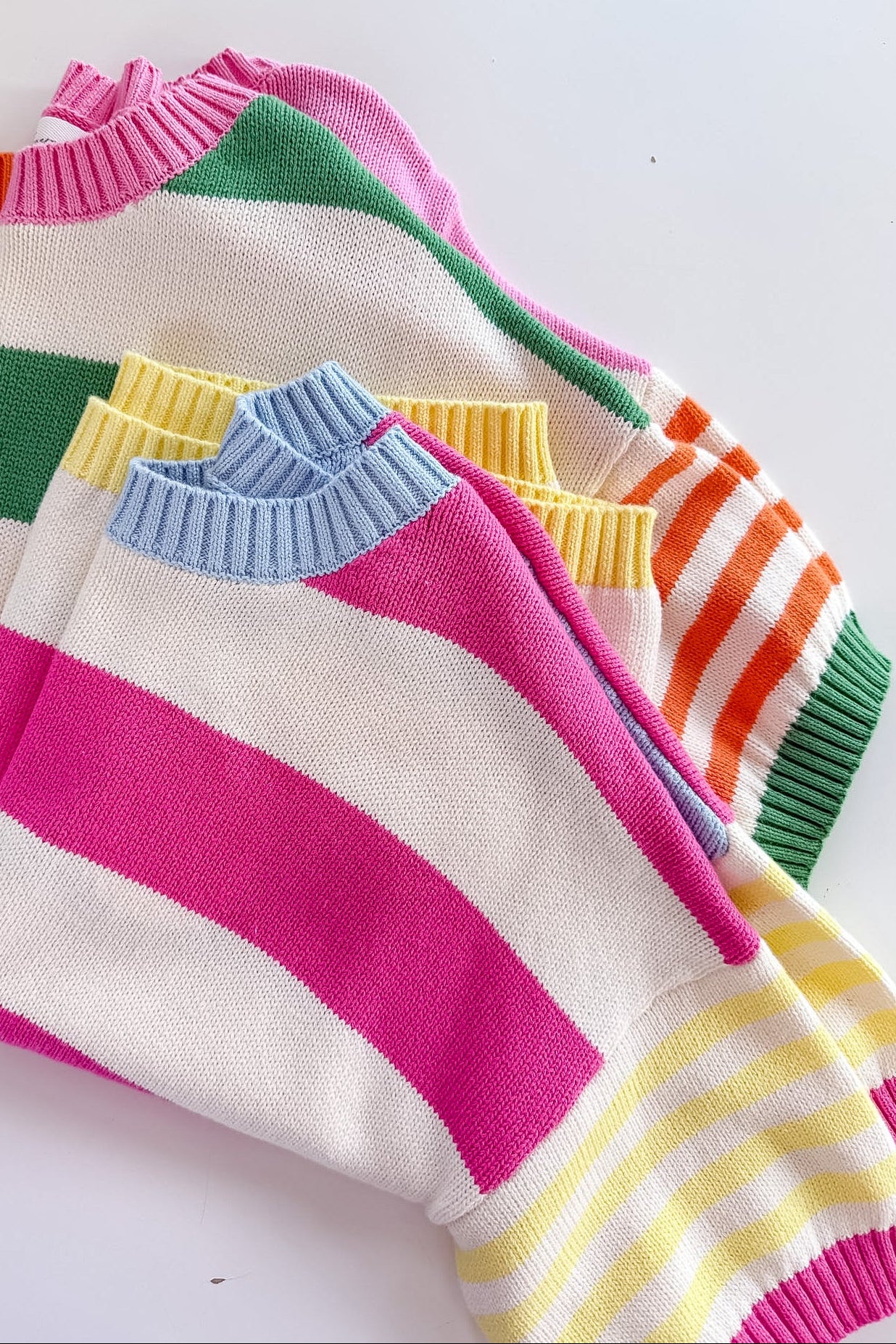 Colorful striped sweaters on a white background