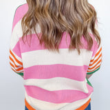 Person wearing a colorful striped sweater with a plain background