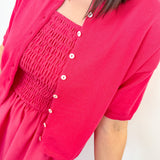 Person wearing a bright pink dress with a matching cardigan on a white background