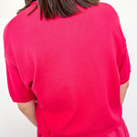 Person wearing a bright pink dress against a white background