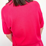Person wearing a bright pink dress against a white background