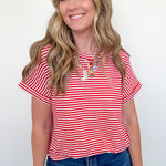 Woman wearing a red and white striped shirt and blue jeans against a white background