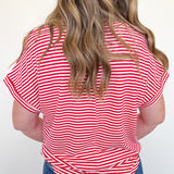 Person wearing a red and white striped shirt with blue jeans on a white background
