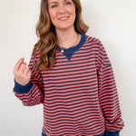 Woman wearing a red and navy striped sweater against a white background