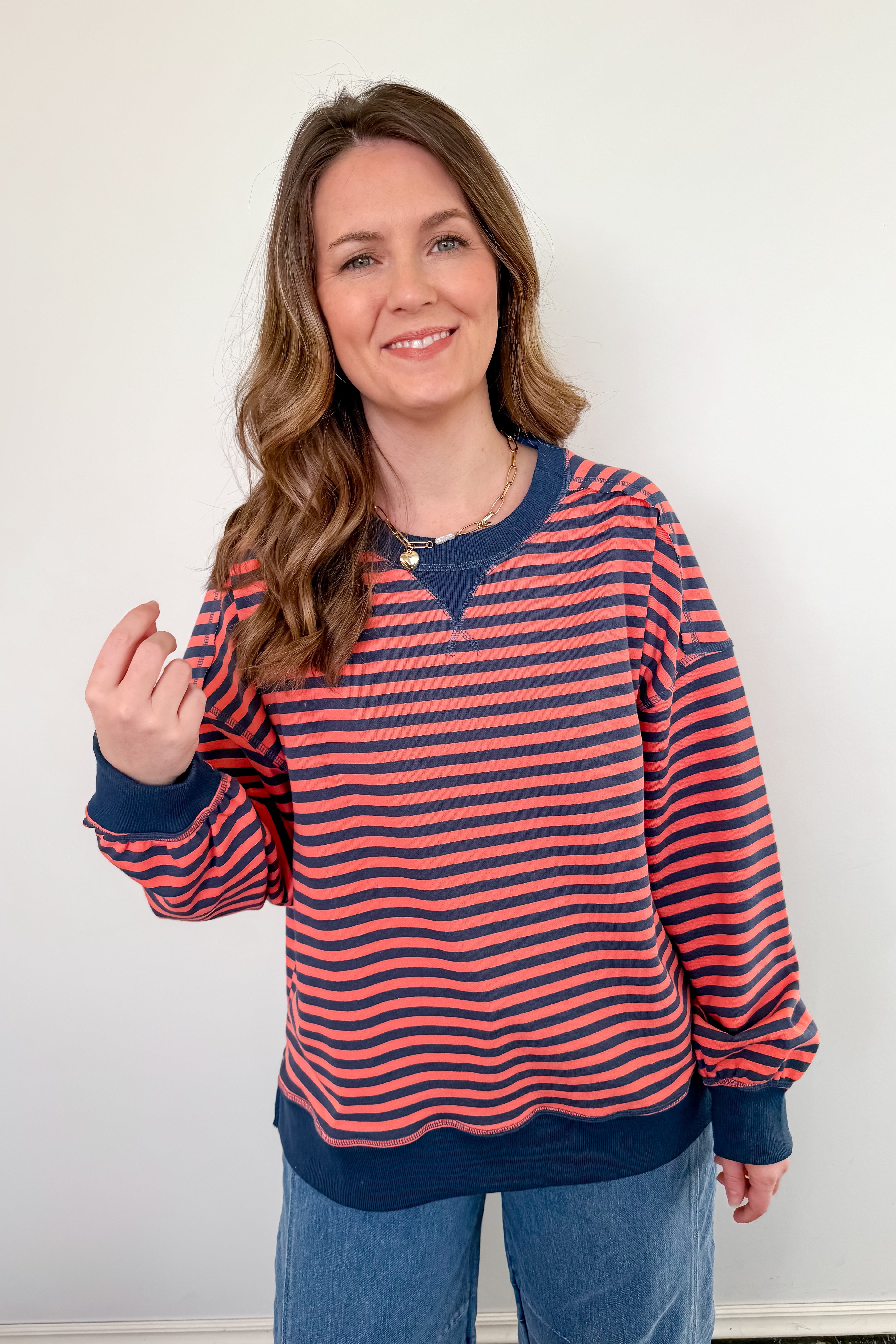 Woman wearing a red and navy striped sweater against a white background