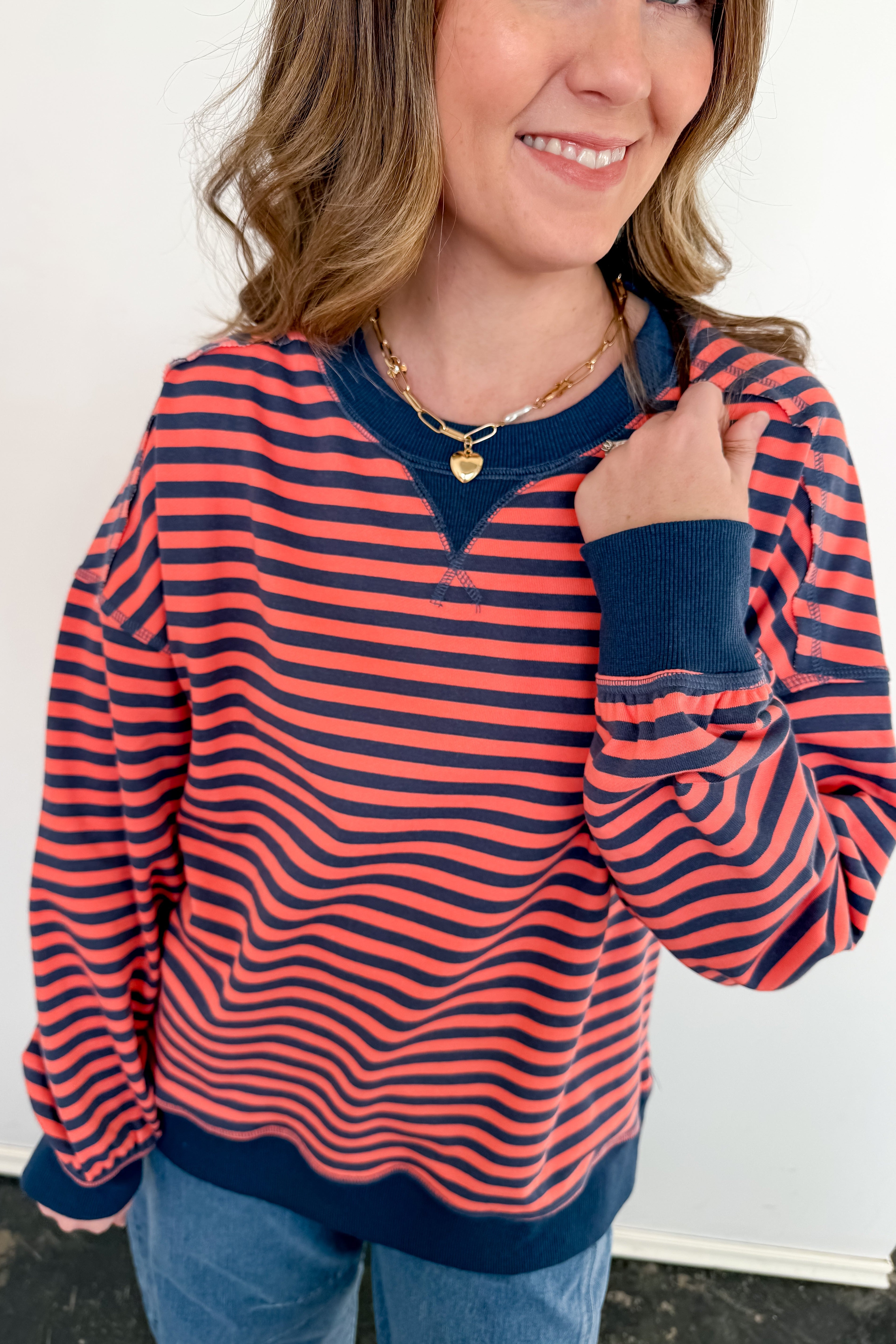 Woman wearing a red and blue striped shirt with a plain background