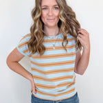 Woman wearing a striped shirt and jeans against a white background