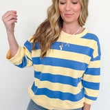 Woman wearing a yellow and blue striped sweater against a white background