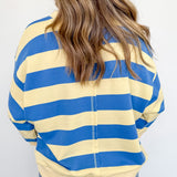 Person wearing a blue and yellow striped shirt with a plain background