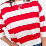 Person wearing a red and white striped shirt with a plain background