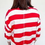 Person wearing a red and white striped shirt with a plain background