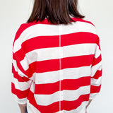 Person wearing a red and white striped shirt with a plain background
