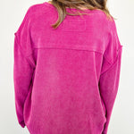 Person wearing a pink corduroy shirt with a white background