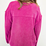 Person wearing a pink corduroy shirt with a white background