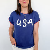 Woman wearing a blue 'USA' t-shirt against a white background
