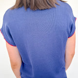 Person wearing a blue sweater with red trim on a white background