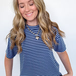 Woman wearing a blue and white striped shirt and jeans against a white background