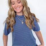 Woman wearing a blue and white striped shirt and jeans against a white background
