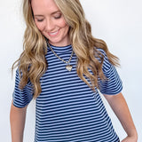 Woman wearing a blue and white striped shirt and jeans against a white background