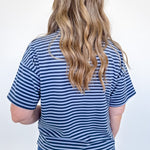 Person wearing a blue and white striped shirt and jeans against a white background