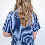 Person wearing a blue and white striped shirt and jeans against a white background