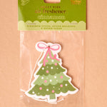 Christmas tree-shaped air freshener in packaging on a beige background