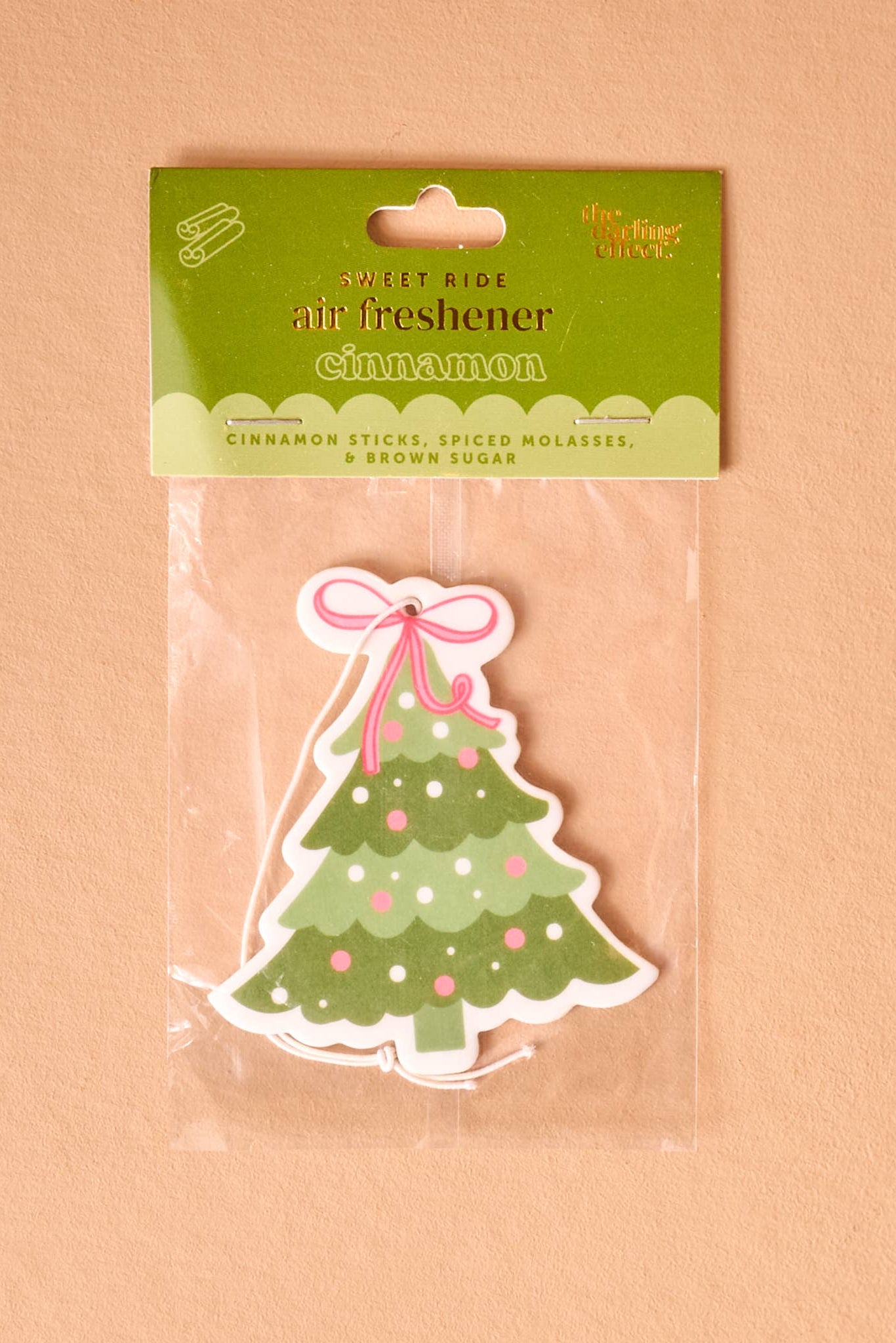 Christmas tree-shaped air freshener in packaging on a beige background